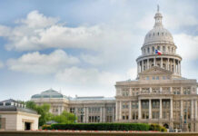 Capitol building with dome under partly cloudy sky.