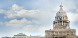 Capitol building with dome under partly cloudy sky.