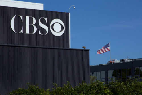 1491307826 CBS sign on building, American flag in background.