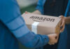 Two people exchanging an Amazon package, outdoors.