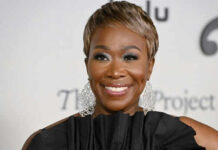 Person smiling wearing large earrings and a black top