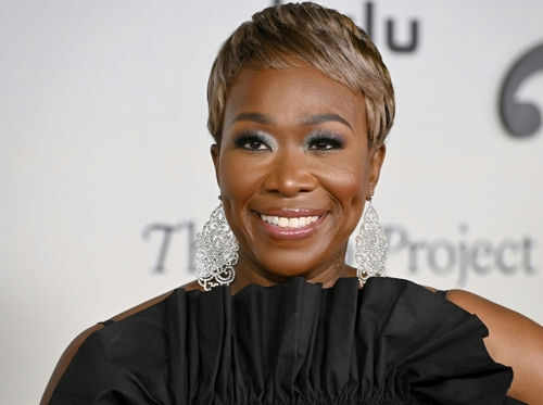 Person smiling wearing large earrings and a black top