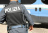 Police officer in uniform standing near blue vehicle