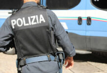 Police officer in uniform standing near blue vehicle