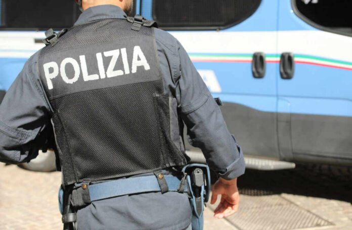 Police officer in uniform standing near blue vehicle