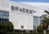 Exterior view of the SpaceX headquarters building with a speed limit sign