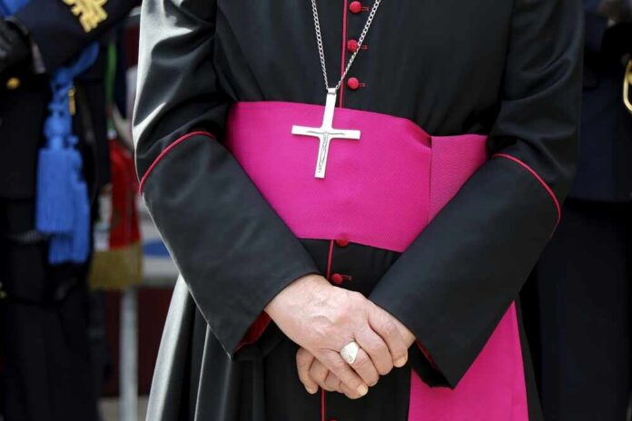 Front,Portrait,Of,A,Catholic,Bishop's,Cassock.,Religion,,Catholic,Church A religious figure in ceremonial attire with a cross necklace