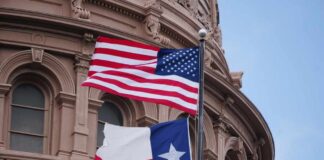 American and Texas flags flying in front of a government building