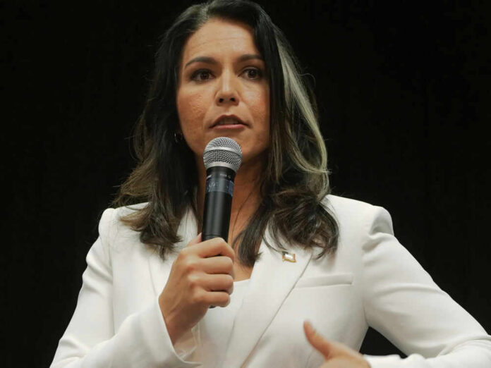 Woman in white suit speaking into a microphone