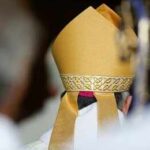 Bishop wearing a golden mitre during a ceremony