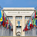 United Nations building with numerous national flags outside.