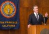 Man in suit giving a speech at a podium