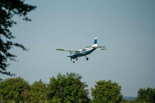 cessna-caravan2492001505jpg Small airplane flying over green trees and clear sky