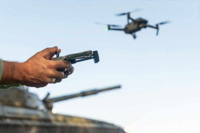 Hands holding a drone controller with quadcopter in flight