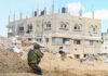 Were Gaza’s Safe Zones Ever Truly Safe? Soldier crouching near damaged building in urban area