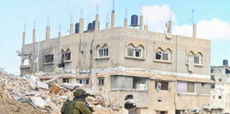 Soldier crouching near damaged building in urban area