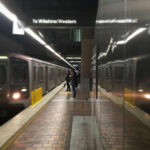 Subway platform with arriving train and commuters waiting