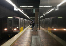 Subway platform with arriving train and commuters waiting