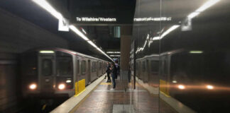 Subway platform with arriving train and commuters waiting