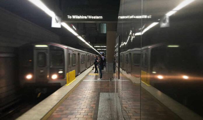 Subway platform with arriving train and commuters waiting