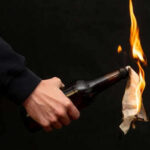 Person holding molotov cocktail with flame burning cloth