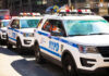Parked row of NYPD police vehicles with flashing lights.
