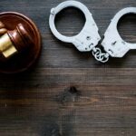 Gavel and handcuffs on wooden table