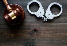 The Influencer Empire Faces Its Biggest Test Gavel and handcuffs on wooden table