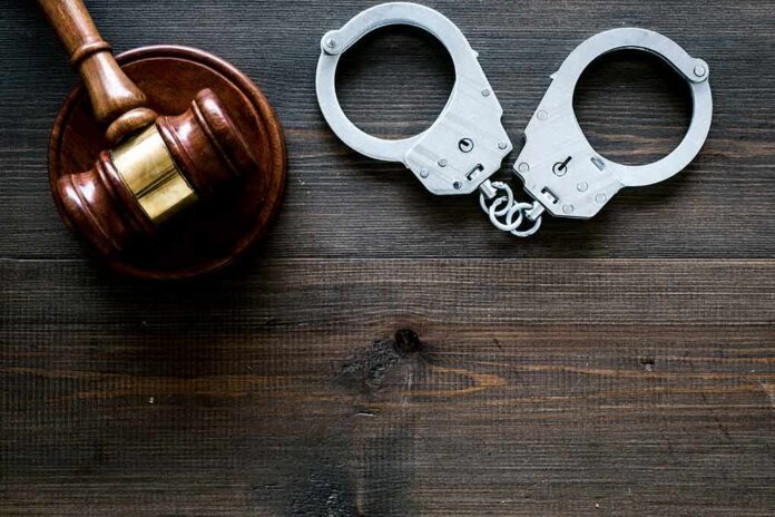 shutterstock_1241661202 Gavel and handcuffs on wooden table