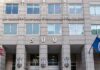 Deadly Raids, Explosive Panel Meltdown US government building facade with flags and number 500