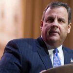 One Joke, Another Trump-Christie Media Firestorm man in suit speaking at a podium