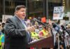 When Crime Came Knocking At The Governor’s Door Speaker at a podium addressing a crowd with microphones and protest signs
