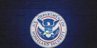 U.S. Department of Homeland Security seal on a blue brick wall