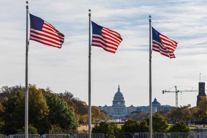 The,United,States,Capitol,Building,With,Us,Flags,In,Washington Three American flags waving in front of the Capitol building