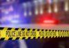 Yellow police caution tape with the text 'POLICE LINE DO NOT CROSS' in a blurred background