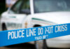 Fugitive Operation Turns Deadly For Federal Marshal Police line marked with caution tape in front of a police vehicle