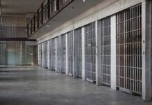 A Mass, A Mob, And 104 Days Jailed prison cell block with metal barred doors