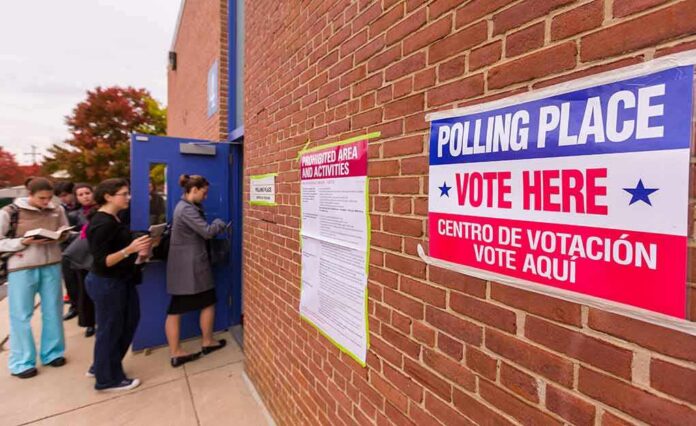 Voters line up outside a brick building polling place