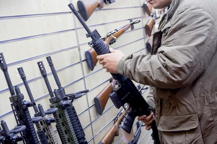 Person examining a black rifle in a gun store