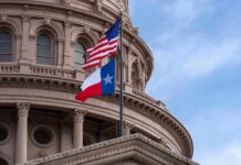 Texas and U.S. flags in front of a capitol building dome