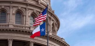 Texas and U.S. flags in front of a capitol building dome