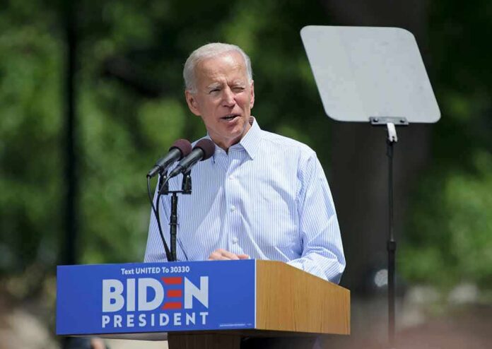 man speaking at an outdoor podium with microphones