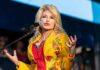 Singer performing on stage in a bright yellow floral jacket