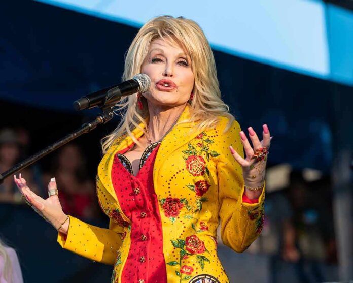 Singer performing on stage in a bright yellow floral jacket
