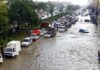 Flooded city street with stranded vehicles and traffic jam