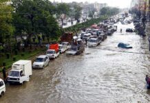 Flooded city street with stranded vehicles and traffic jam