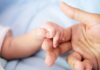 baby hand holding adult finger