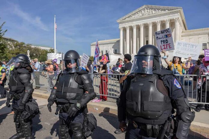 Riot police stand in front of a courthouse during a protest