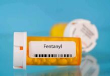 Prescription pill bottle labeled fentanyl on a blue background