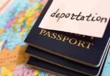 Stack of passports with a note labeled deportation on top, placed on a map